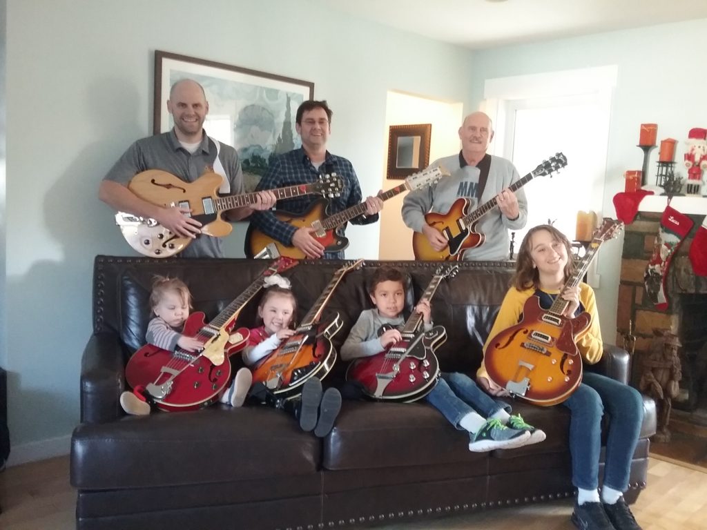 My two sons and four grand children holding Japanese copies of a Gibson 335. I'm holding the only real Gibson. 